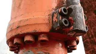 Close-up of a hydraulic cylinder with bolts