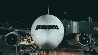 White airliner lit up on the apron at night