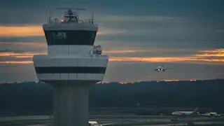 Large aircraft flying low over a runway