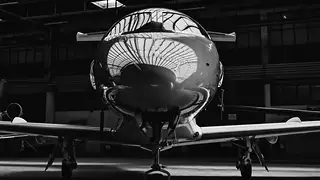Business jet inside a hangar, black and white