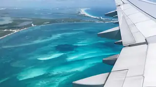 Aircraft wing over the Caribbean Sea near Cancún, Mexico